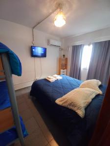 a bedroom with a bed and a tv on the wall at El Canto de la Ballena Loft 1 in Puerto Pirámides