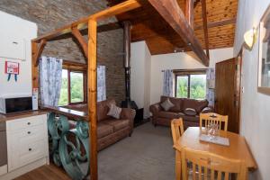 a living room with a couch and a table at Treetop View - Old Mill Cottages in Ilfracombe