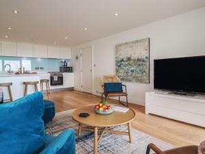 a living room with a blue couch and a table at 4 Ocean Gate in Newquay