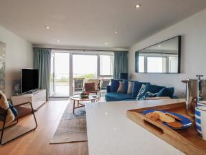 a living room with a blue couch and a table at 4 Ocean Gate in Newquay