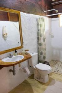 a bathroom with a toilet and a sink and a mirror at Mareselva Lodge in Acanti +40 photos