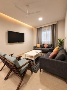 a living room with a couch and a tv at ملاذ للشقق المخدومة in Salalah