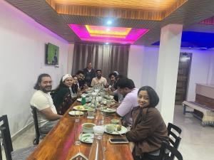 a group of people sitting around a wooden table at Laxman Homestay in Sarāhan +11 photos