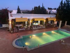a large swimming pool in front of a house at Villa pamplemousse in Banī ‘Aţāʼ