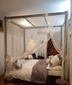 a bed with a canopy in a bedroom at Rimbud guest house in Hārer +2 photos