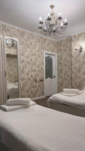 a bedroom with two beds and a chandelier at Абдрахманова 176 in Bishkek