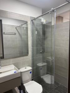 a bathroom with a toilet and a glass shower at Hermosos Apartaestudios! in Florencia +30 photos