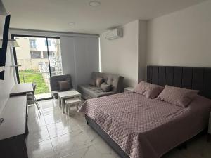 a bedroom with a bed and a couch and a window at Hermosos Apartaestudios! in Florencia