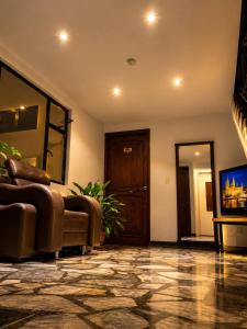 a living room with a couch and a tv at Hotel Posada Leon in Pasto