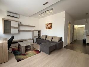 a living room with a couch and a table at LOTZ Apartman in Pécs