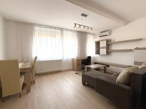 a living room with a couch and a table and a desk at LOTZ Apartman in Pécs