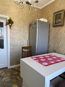 a kitchen with a white refrigerator and a table at Абдрахманова 176 in Bishkek
