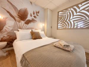a bedroom with a large bed and a painting on the wall at La Maison De Colette in Lezoux