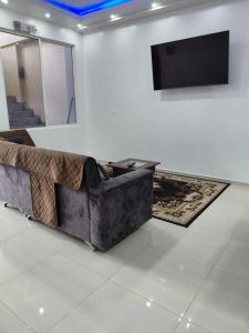 a living room with a couch and a flat screen tv at Casa Puka in Puerto Baquerizo Moreno