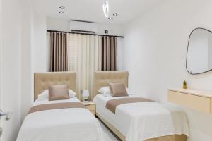 two beds in a room with a mirror at Villa MONTE Ulcinj in Stegvaši