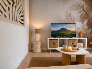 a living room with a tv and a table at La Maison De Colette in Lezoux