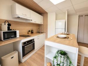 a kitchen with white cabinets and a counter top at La Maison De Colette in Lezoux +16 photos