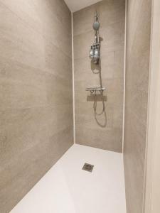 a bathroom with a shower with a shower head at La Maison De Colette in Lezoux