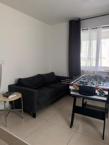a living room with a black couch and a table at Mon-Chery in San Ġwann