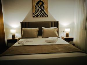 a bedroom with a bed with two lamps on it at Palm Paradise in Sukrah +21 photos