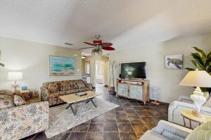 a living room with couches and a flat screen tv at Golden Palms in Laguna Vista