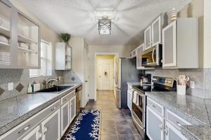 a large kitchen with white cabinets and a sink at Golden Palms in Laguna Vista