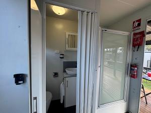 a bathroom with a toilet and a sliding glass door at Camden Holiday Park in Camden +28 photos