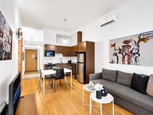 a living room with a couch and a table at LiV MTL Main Plateau Suites Near Downtown Montreal in Montreal