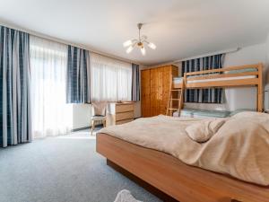 a bedroom with a bunk bed and a desk at Nussbaumer S in Niedernsill