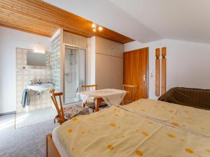 a bedroom with two beds and a bathroom with a sink at Nussbaumer in Niedernsill