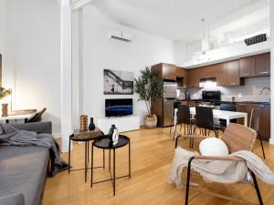 a living room with a couch and chairs and a kitchen at LiV MTL Main Plateau Suites Near Downtown Montreal in Montreal