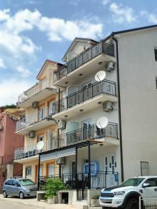a building with balconies and cars parked in front of it at Montenegro Summer time in Igalo