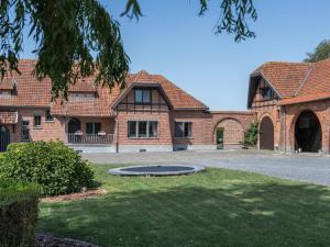 a brick house with a trampoline in the yard at Rozenberghoeve in Ploegsteert