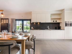 a kitchen with a wooden table with chairs and a dining room at Rozenberghoeve in Ploegsteert