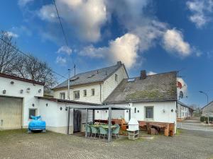 a white house with a table and chairs in a yard at Großlangenfeld in Großlangenfeld