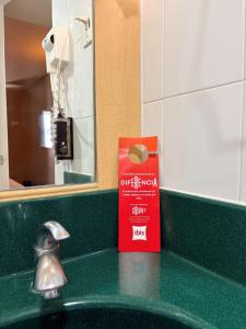 a bathroom sink with a red box next to a mirror at Ibis Monterrey Valle in Monterrey +72 photos