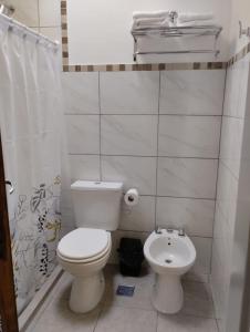 a white bathroom with a toilet and a sink at Annie in La Falda