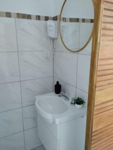 a white bathroom with a sink and a mirror at Annie in La Falda