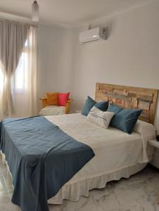 a bedroom with a large bed with blue pillows at Annie in La Falda