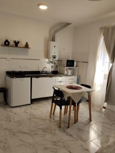a kitchen with a table and a table and chairs at Annie in La Falda