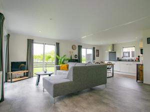 a living room with a couch and a kitchen at De Zwaluw in Heiloo
