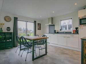 a kitchen with a table and chairs and a clock at De Zwaluw in Heiloo +22 photos