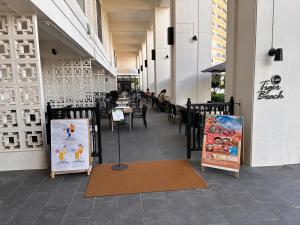 a restaurant with tables and chairs in a building at Prince Plage OKINAWA 6F in Fuzuchi