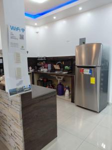 a kitchen with a stainless steel refrigerator in a room at Casa Puka in Puerto Baquerizo Moreno