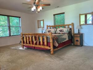 a bedroom with a wooden bed and a ceiling fan at Further Up & Further In in Topton