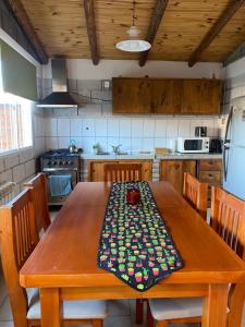 a kitchen with a wooden table with a table cloth on it at Los Duraznillos in Los Antiguos +12 photos