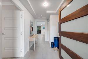 a hallway with a door leading into a room with white walls at Hideaway -4BR Family Home with Pool, Near Beach in Caloundra