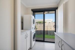 a kitchen with a washer and dryer in a house at Hideaway -4BR Family Home with Pool, Near Beach in Caloundra