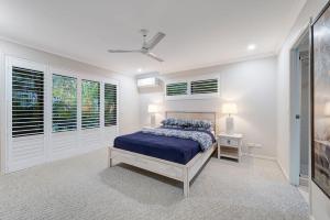 a bedroom with a bed and a ceiling fan at Hideaway -4BR Family Home with Pool, Near Beach in Caloundra +9 photos