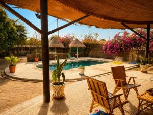 a patio with two chairs and a swimming pool at Villa Farou in Mbour